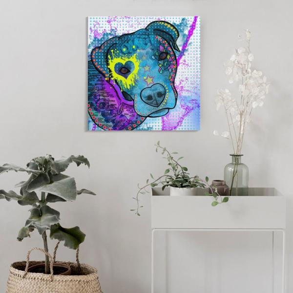 Das Bild von Boogie hängt an einer Wand. Davor steht ein weißes Sideboard mit einer kleinen grnen Kletterpflanze und einer Flasche mit einer weißen Blume darin. Links daneben steht eine grüne Pflanze in einem geflochtenen Korb