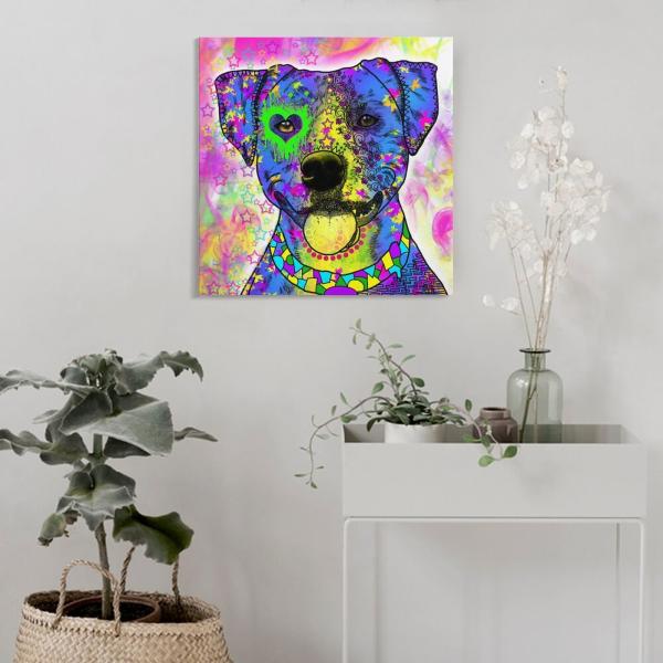 Das Hundebild Tayra hängt an einer Wand. Davor steht eine Pflanze und ein Sideboard